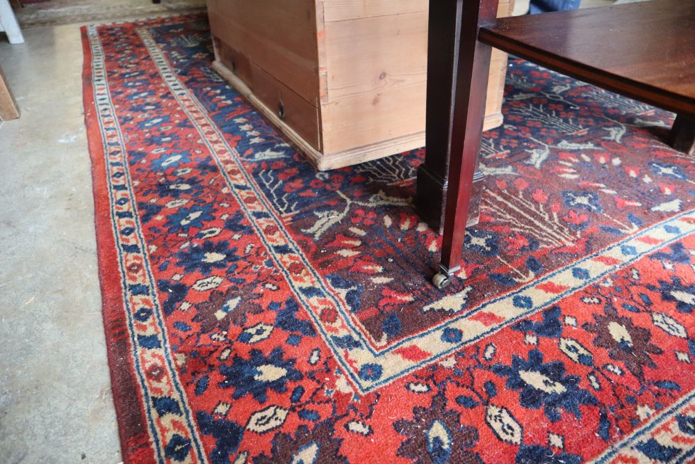 A North West Persian style red and blue ground carpet, 300 x 190cm